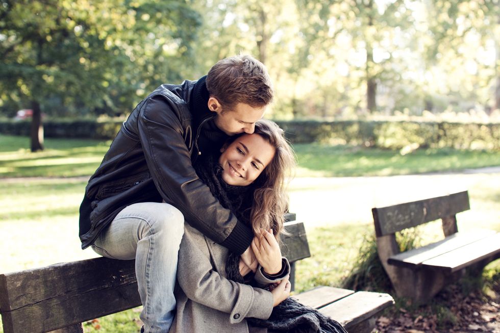 Young couple sitting on bench outdoor.