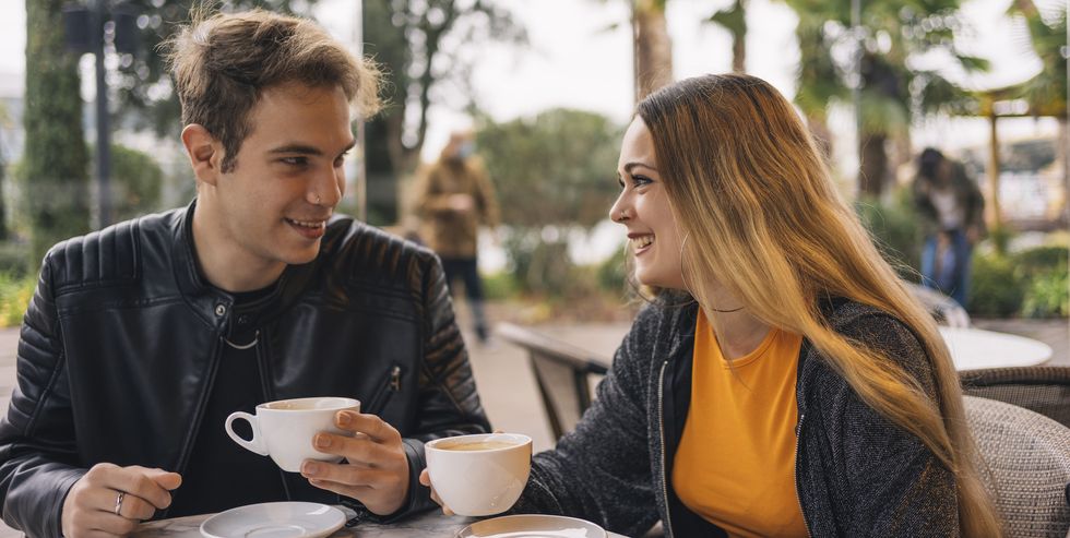 young couple talking while drinking coffee in a coffee shop