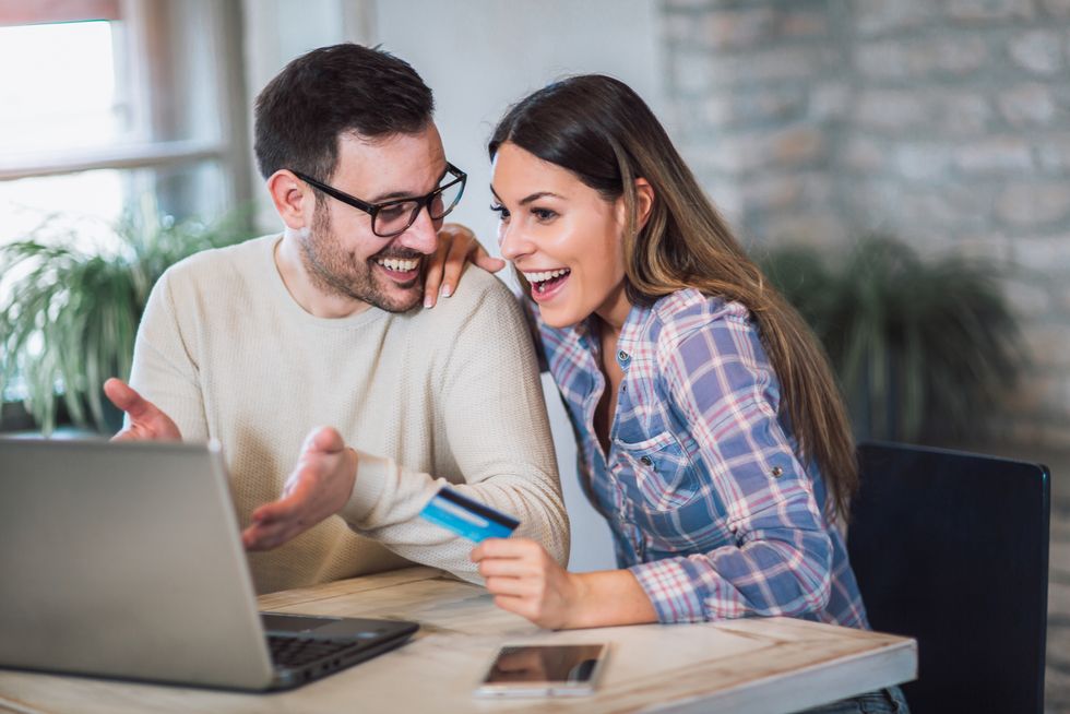 young couple with laptop computer and credit card buying online