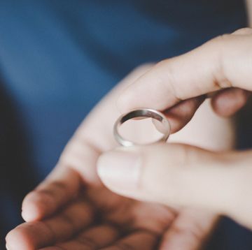 a young couple's hands holding a wedding ring, a concept of divorce