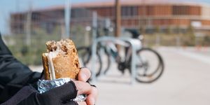 young cyclist man eating a sandwich