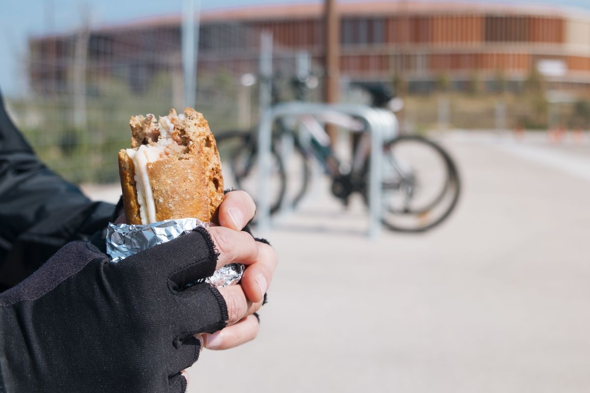 young cyclist man eating a sandwich