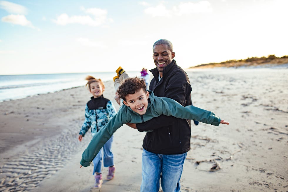 young family enjoying time on the beach during winter