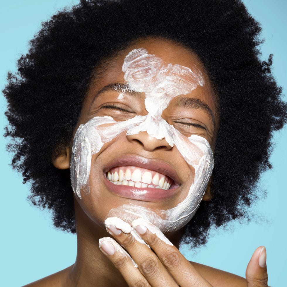 Young female applying face cream / mask young female applying face cream