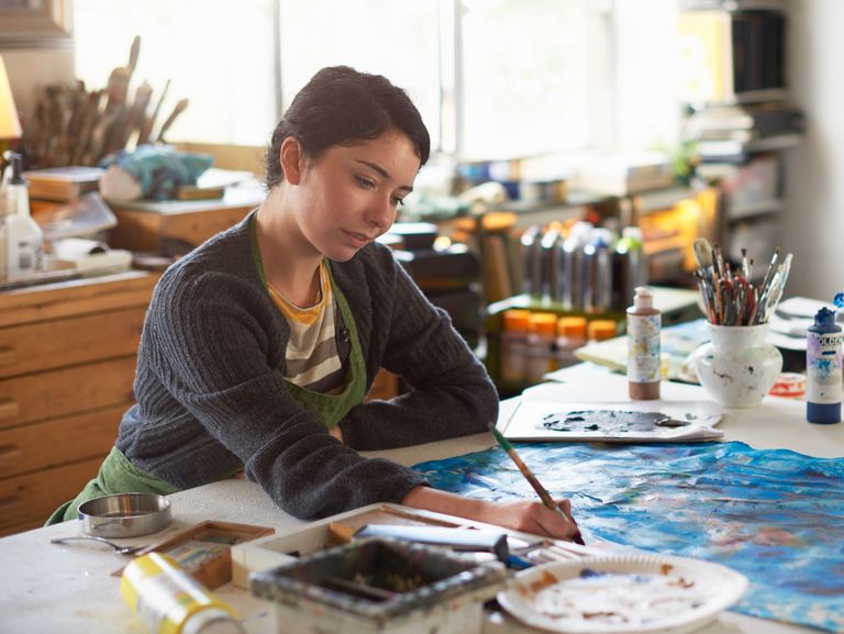 a young female artist working in her studio