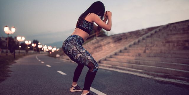 Young Female Athlete Doing Squats on Running Path