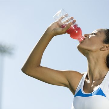 young female athlete drinking sports drink, portrait