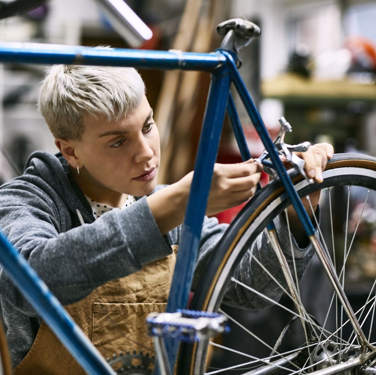 young female employee repairing bicycle brake