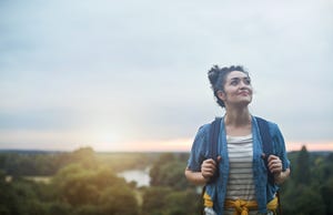 young female hiker climbing hill