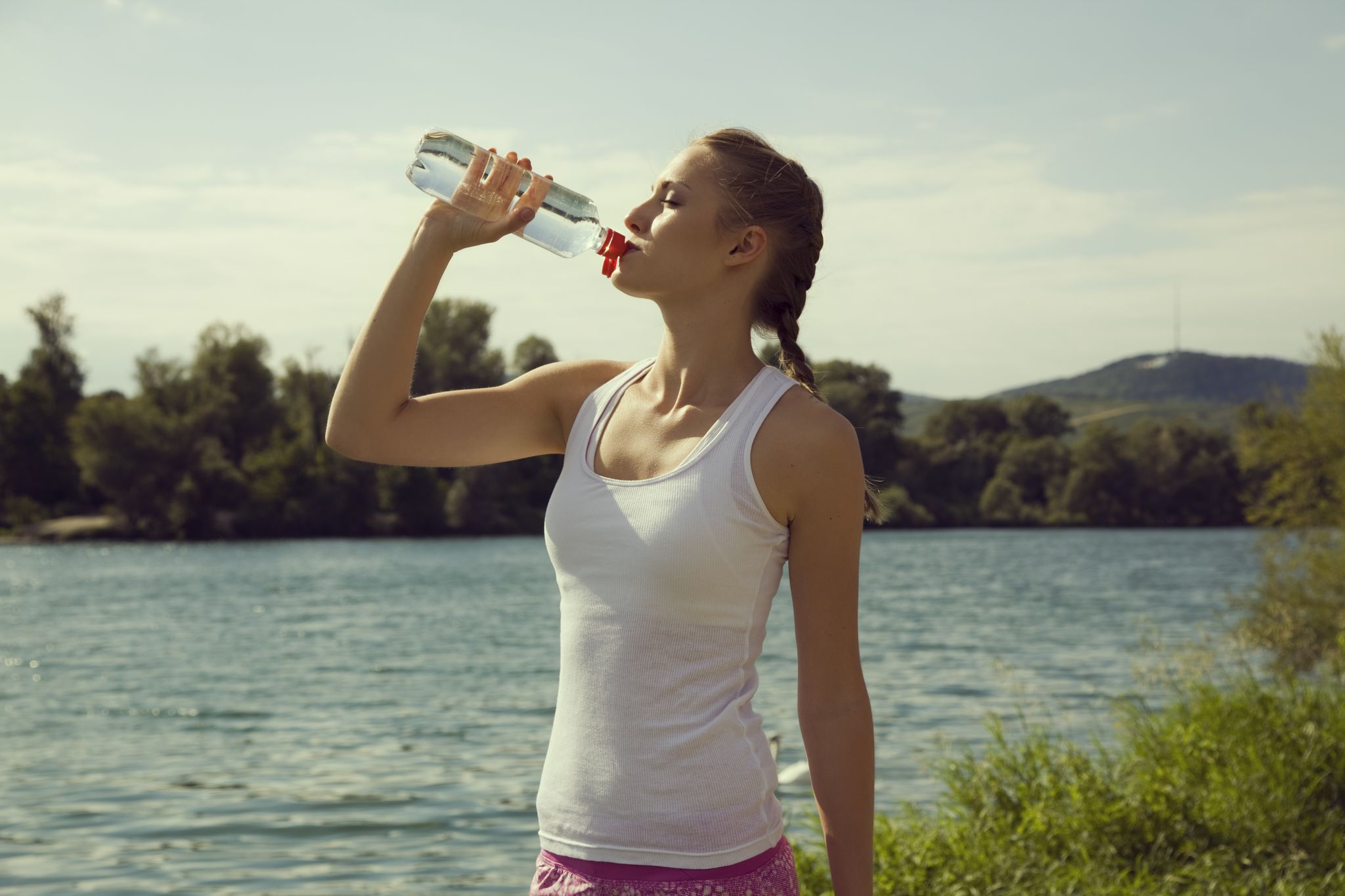 Young female jogger drinking bottled water