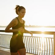 Young female jogger running learning sunrise