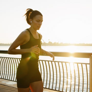 Young female jogger running at sunrise