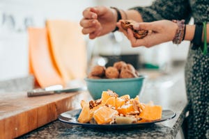 young female preparing fruit salad on the kitchen