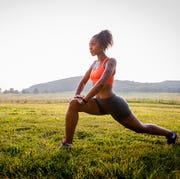 young female runner stretching in rural park