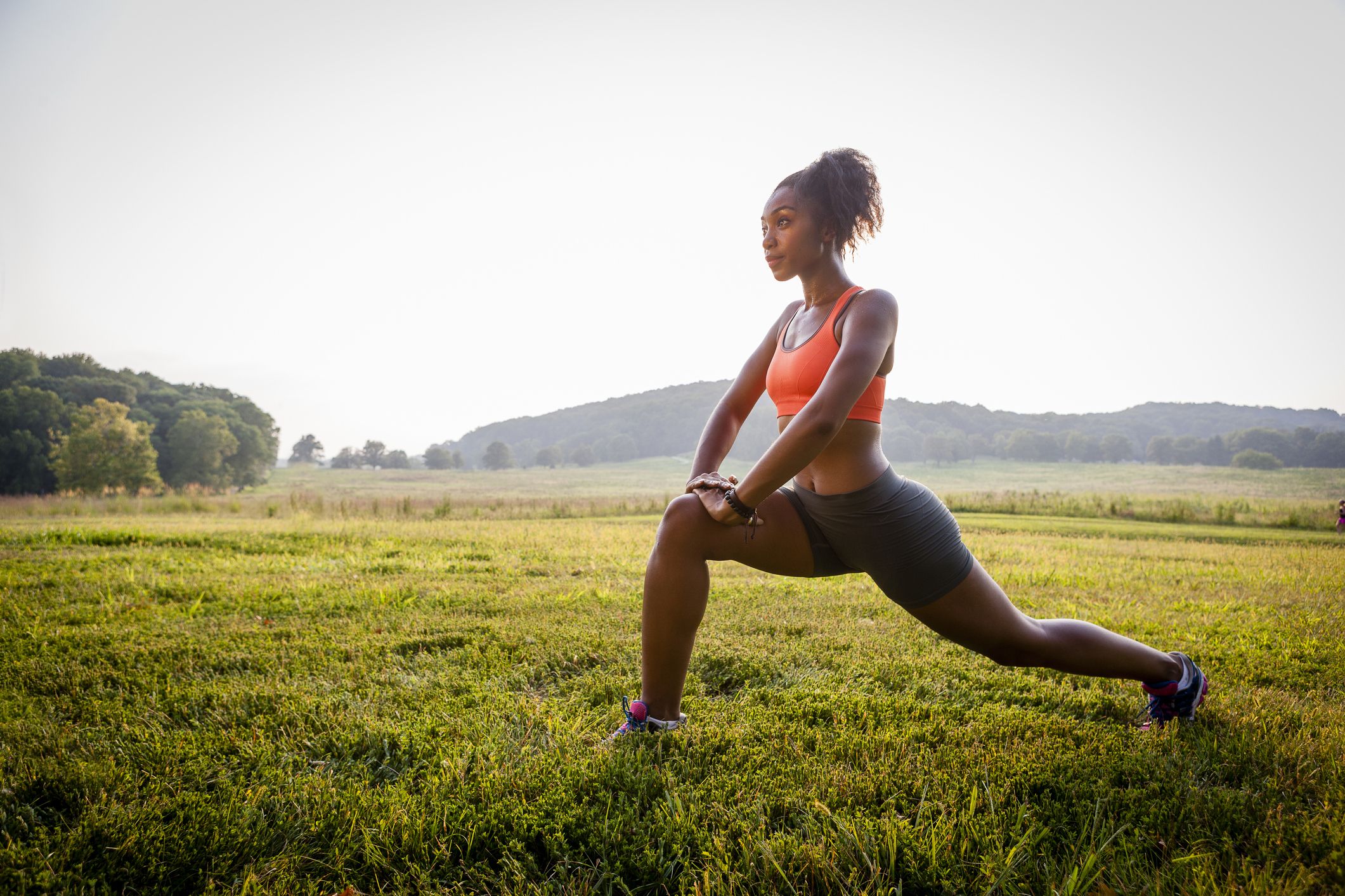 Young woman stretching after running in nature. Fitness women
