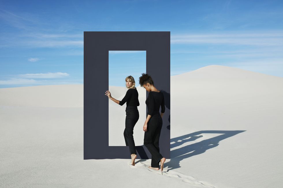 young females walking through door frame at desert