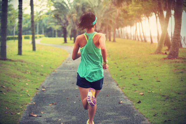 young fitness sports woman runner running on tropical park trail