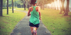 young fitness sports woman runner running on tropical park trail