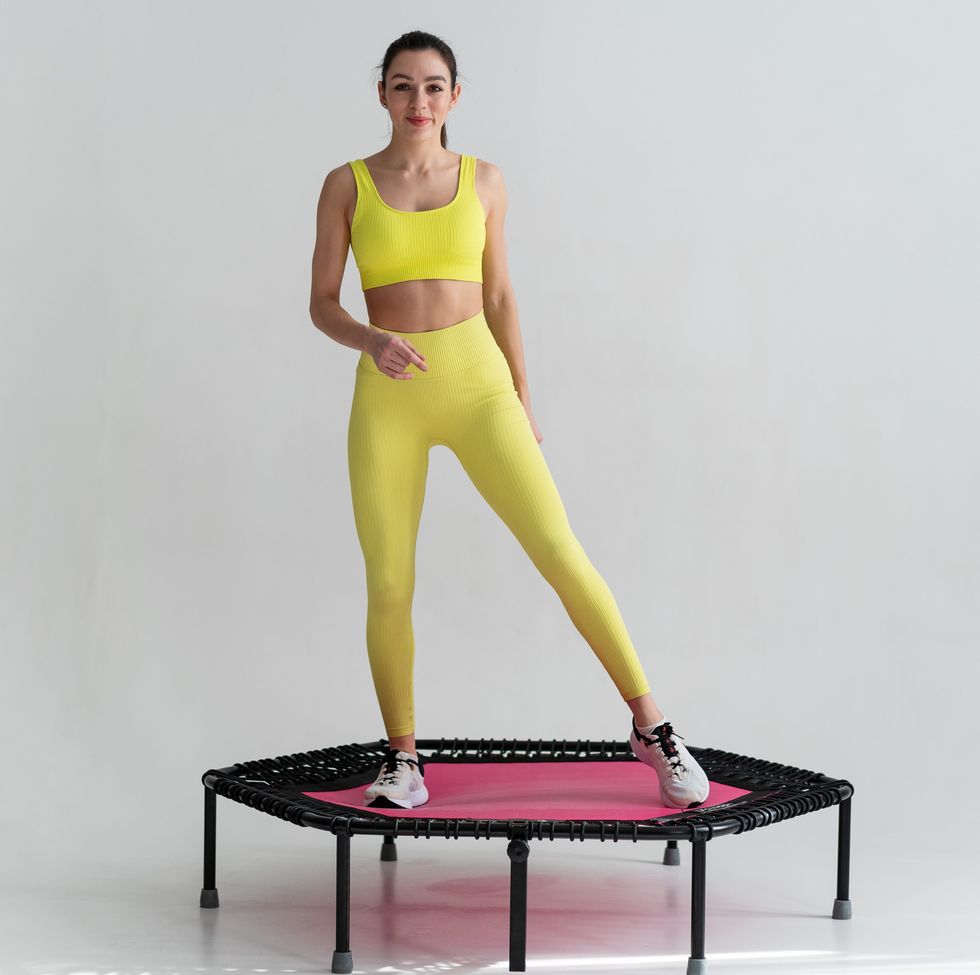 young fitness woman in sportswear jumping on sport trampoline