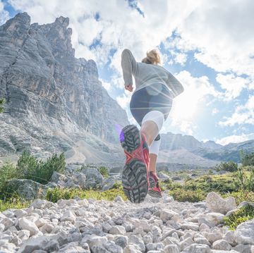 young fitted woman trail running in the dolomites, italy