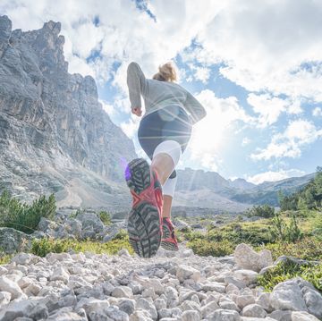 young fitted woman trail running in the dolomites, italy