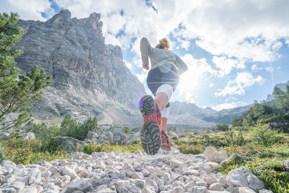 young fitted woman trail running in the dolomites, italy