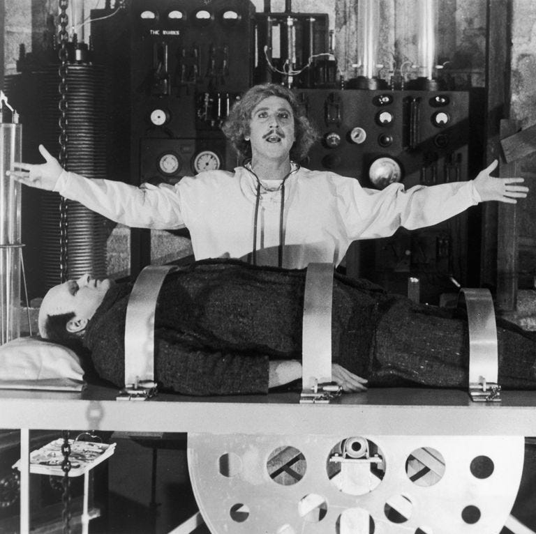 dr frederick frankenstein stands over a body in a scene from young frankenstein a good housekeeping pick for best halloween movies