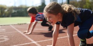young girl and boy ready to race on an athletics track