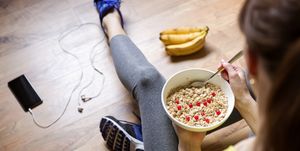 Young girl eating a oatmeal with berries after a workout . Fitness and healthy lifestyle concept.