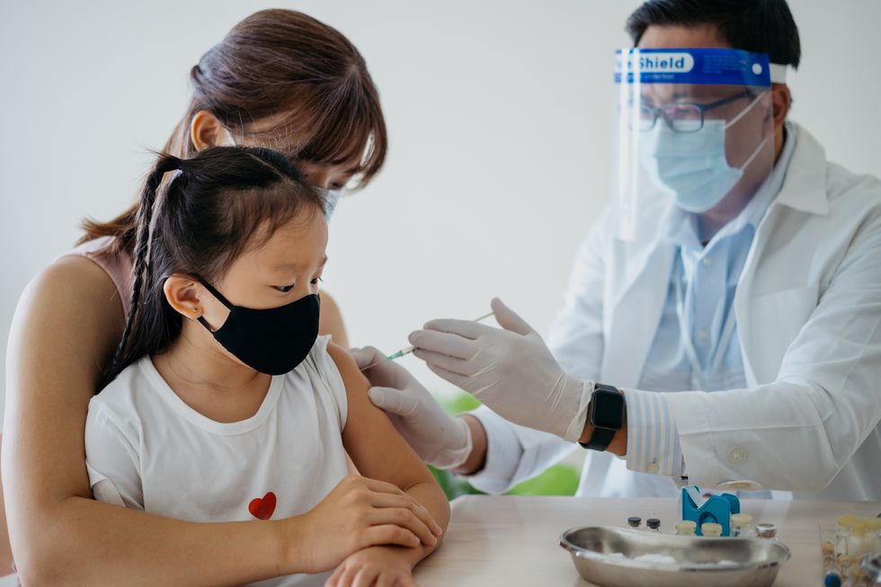 young girl getting a vaccine injection on her arm