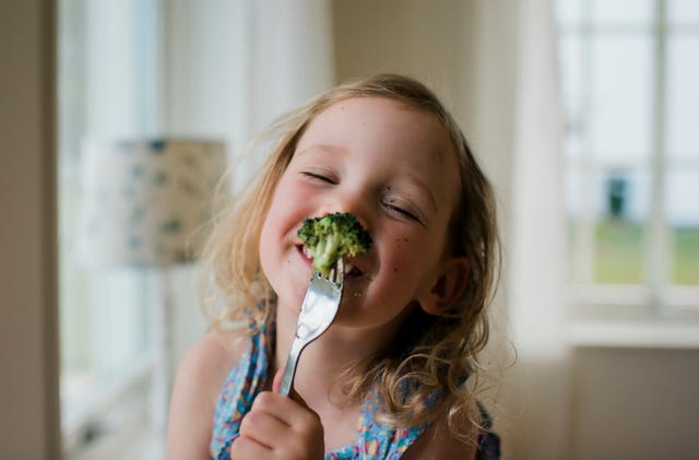niña con brócoli en tenedor