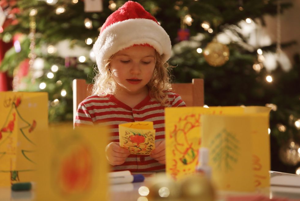 young girl making homemade christmas cards