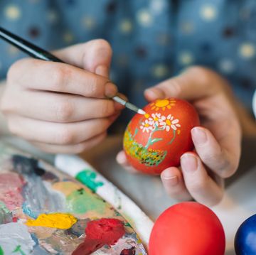 young girl painting on easter egg