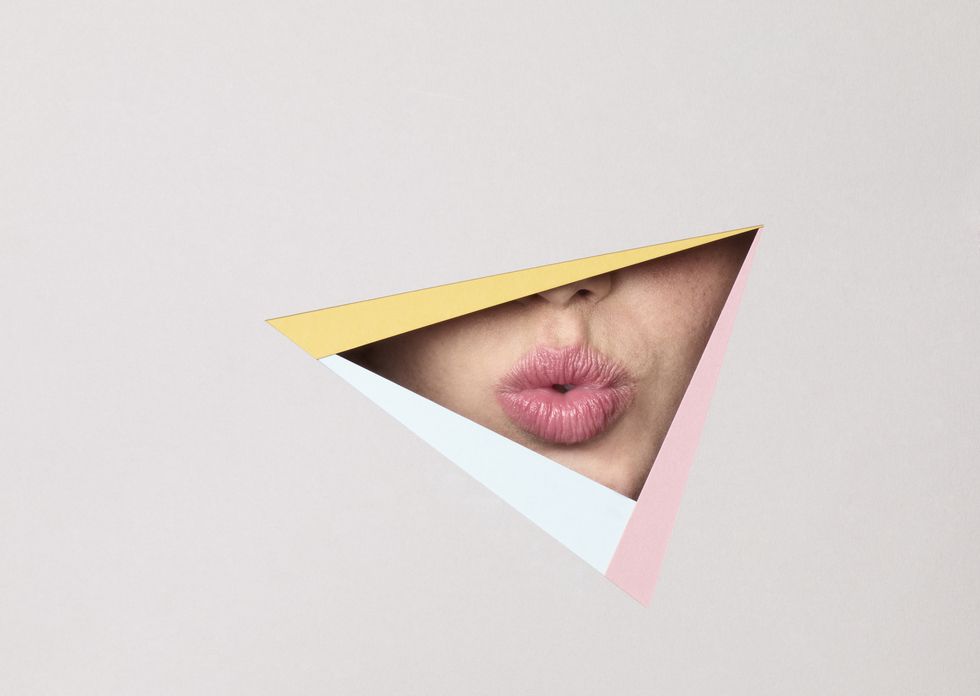 young girls lips viewed through paper cut out