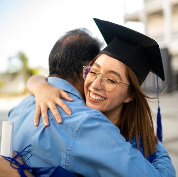 young graduate embracing father on her graduation day