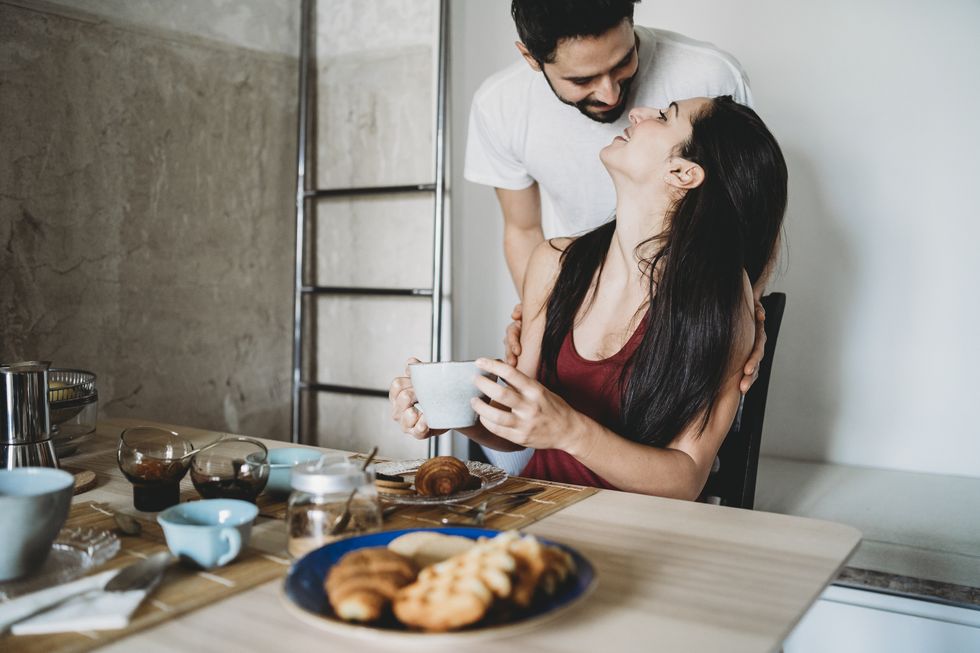 young happy couple in love having breakfast at the kitchen table