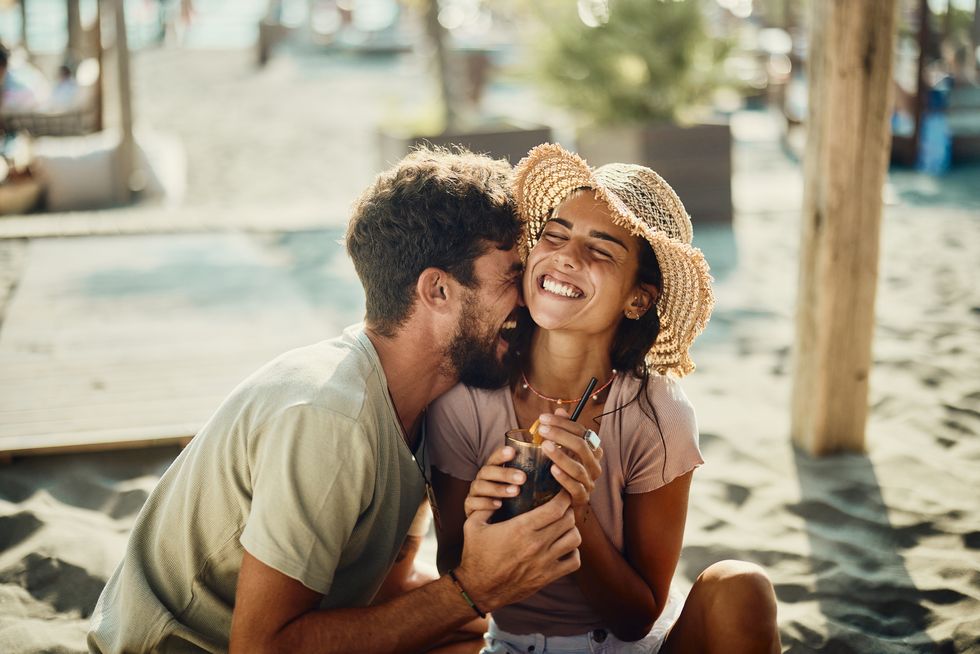 young happy couple in love having fun in a beach café