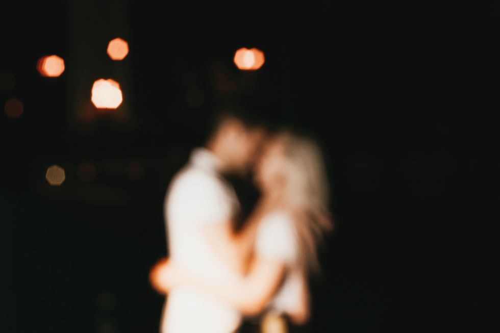 young happy couple in love kissing in night blurred background