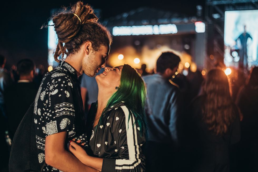young happy couple kissing at music festival