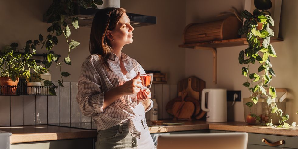 young happy woman drinking coffee on the kitchen in the morning