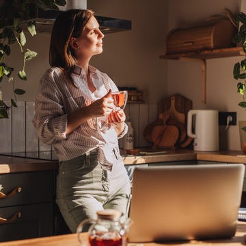 young happy woman drinking coffee on the kitchen in the morning