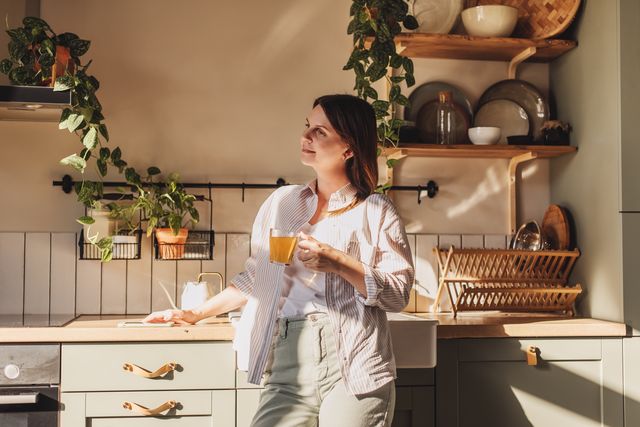 young happy woman drinking coffee on the kitchen in the morning.