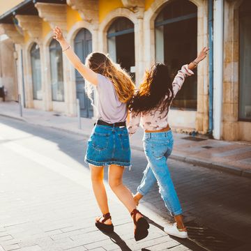 young hipster women on holidays walking cheerfully in old streets