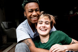 a young lgbt couple laughing and hugging