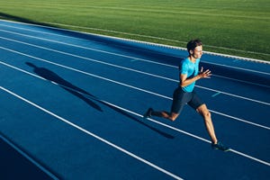 Young male athlete training on a race track