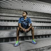 young male runner sitting on city steps