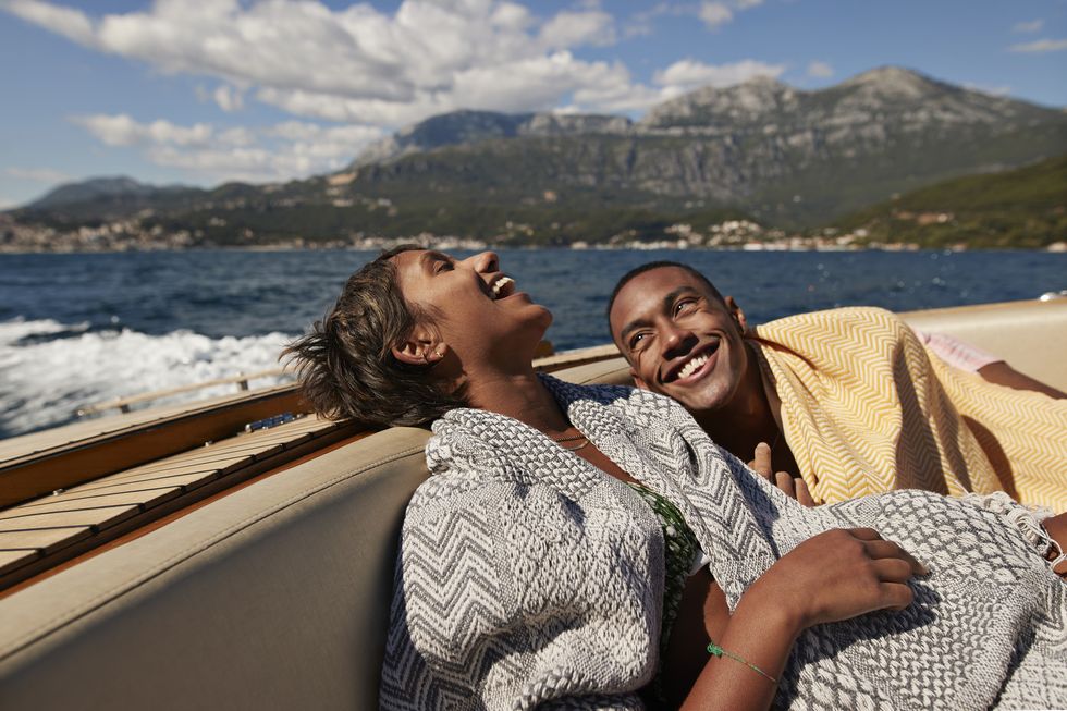 young man and woman laughing in speedboat