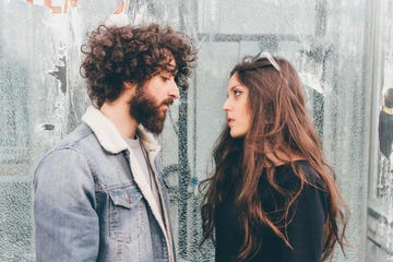 young man and woman, standing face to face, pensive expressions