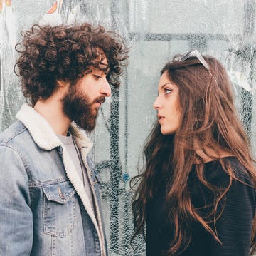 young man and woman, standing face to face, pensive expressions