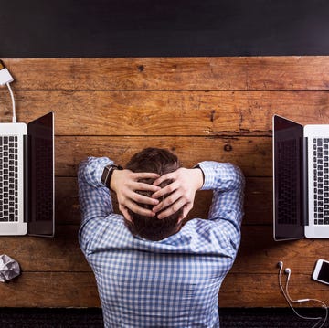 Young man at work, hands on head